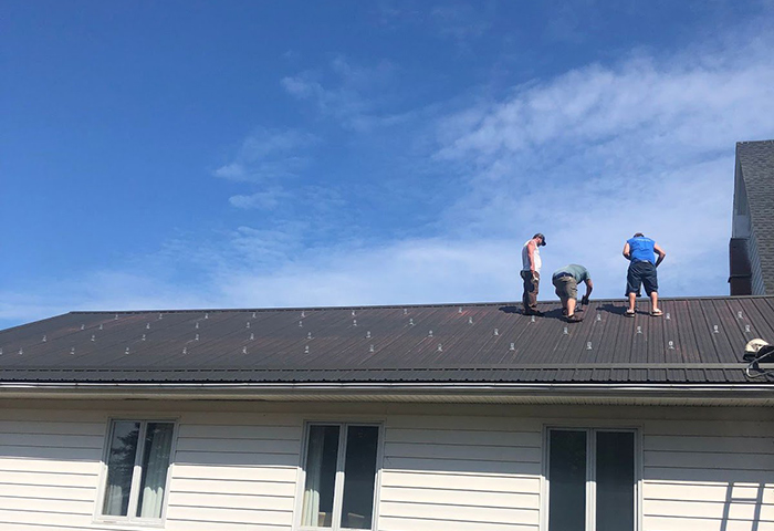 People on roof of Old Barns United installing solar panels