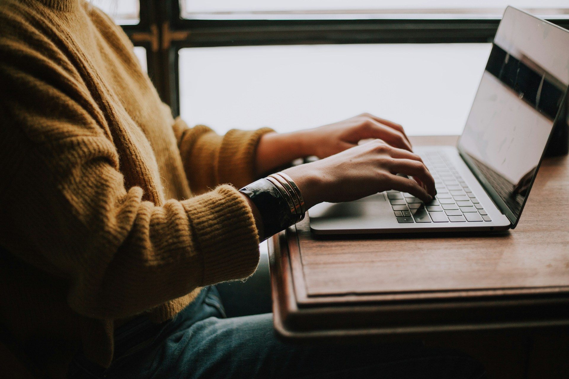 Person sitting in a cafe using a laptop to browse the internet