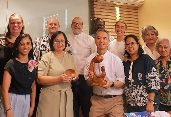 A group of people holding a small statuette.