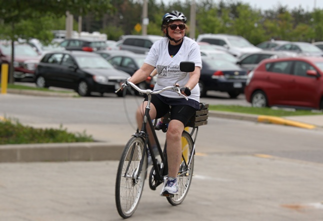 Mardi Tindal riding a bicycle wearing shorts, arriving at GC43
