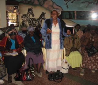 A grandmother in Kenya tells her story to a room of grandmothers.