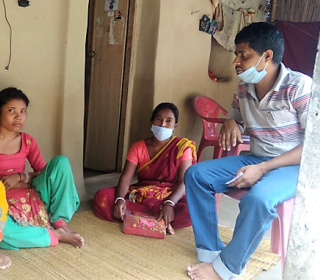 Lakshmi with her parents on porch, India