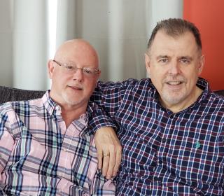 Harry Stewart and Chris Southin, founders of Rainbow Camp, seated on sofa