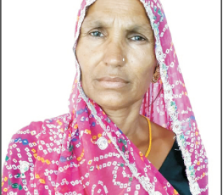 Headshot of Maina Bai, an Indian woman, in a pattern pink sari.