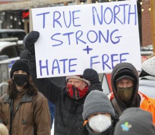 counter protest with sign that says True North Strong and Hate Free
