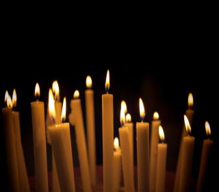 Numerous candles shine in the night.