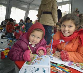 Two young refugees from Afghanistan play in a Serbian refugee centre.
