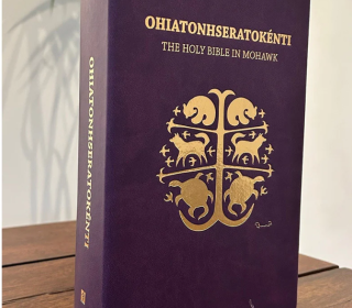 The Mohawk Bible has a purple cover with Indigenous art stamped in gold