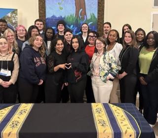 Large group of young people pose in front of Canadian Foodgrains Bank banner