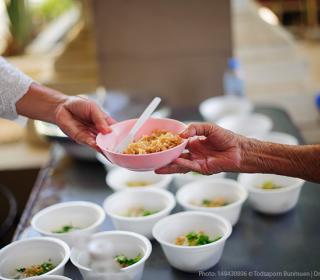 Hands holding a bowl of food