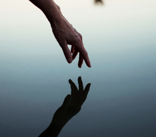 A hand reflected in calm water