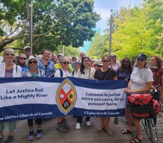 Members of the United Church hold a banner at the Grassy Narrows march in Toronto