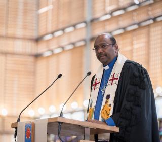 A photo of Rev. Prof. Dr. Jerry Pillay speaking at a lectern.