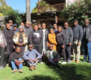 A group of about 25 participants gathered outside in the morning sun.