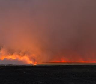 A wildfire burns on a horizon