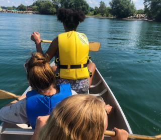 Children at Cave Springs Camp paddle a canoe