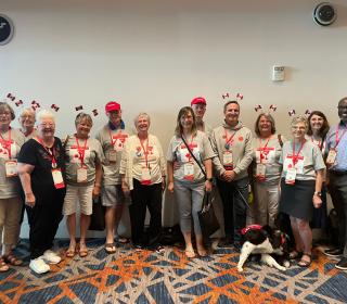 A group of individuals in a boardroom, many wearing Canadian flag headbands.