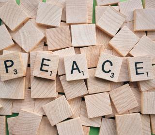Scrabble letter tiles spelling out "Peace"
