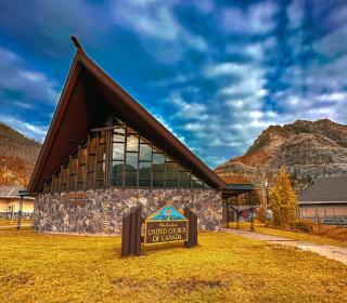 Waterton United Church with mountains and blue sky