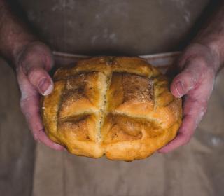 Hands holding a loaf of bread