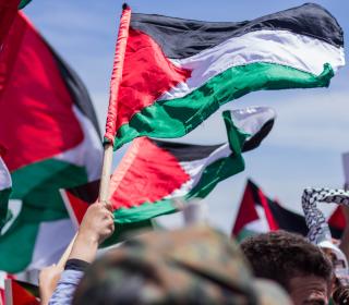 Palestinian flags are lifted during a protest