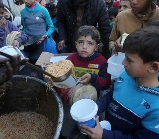 Children gather to receive food from a charity in Gaza