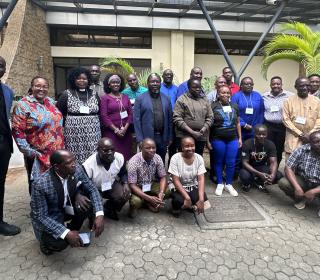 A group of African clergy and lay people outside of a building