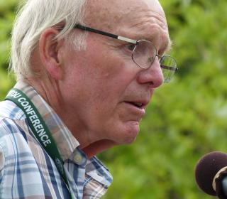The Very Rev. Dr. Robert F. Smith speaking into a microphone