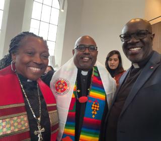 Three people taking a selfie in clerical collars and robes