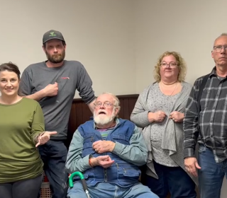 A group of five people demonstrating American Sign Language