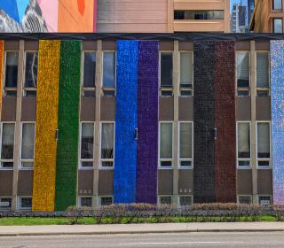 An exterior church wall painted in rainbow colours