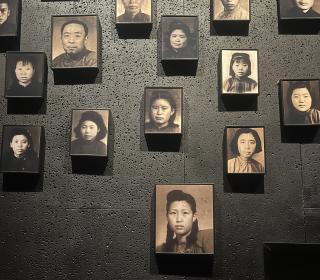 A wall hung with black and white photos of Chinese men and women from the 20th century.