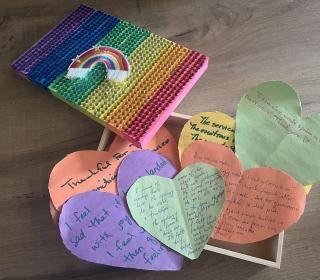 Rainbow hearts made of paper with writing on them