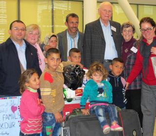 A refugee family from Syria is welcomed at the airport by their sponsors