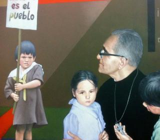 A detail from a mural at Monseñor Óscar Arnulfo Romero International Airport in El Salvador, showing Archbishop Oscar Romero and several children, one holding a sign that says "Mi amor es el pueblo" ("My love is the people.")