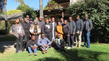 A group of about 25 participants gathered outside in the morning sun.