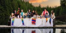 "A Place at the Table" - an iconic image of 12 diverse disciples at a long table, positioned on a dock in a mountain lake.