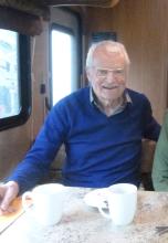 A smiling man with grey hair and glasses