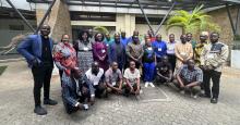 A group of African clergy and lay people outside of a building