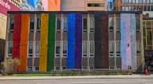 An exterior church wall painted in rainbow colours