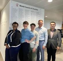 A group of people pose in front of a wall that reads "World Council of Churches"