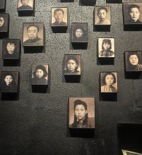 A wall hung with black and white photos of Chinese men and women from the 20th century.