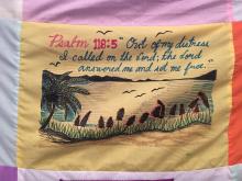 A blanket from the National Inquiry, sharing the poignant words of Psalm 118:5 and a drawing of a shoreline and a lake.
