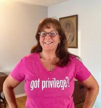 The author, Karen Orlandi, wears a pink shirt with the words, "Got Privilege?" printed on the front in bold letters. 