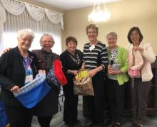 Author YoonOk Shin and the United Church Women of Alberta and Northwest Conference pose for a group shot with the shopping bags they sewed.