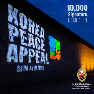 The words "Korean Peace Appeal" projected on a large wall at night time in support of the Korea Signature Campaign