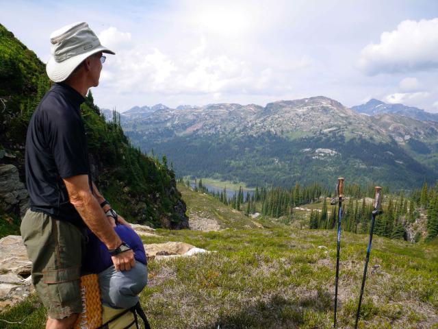 Bill on a mountain, looking over the valley and the mountains beyond