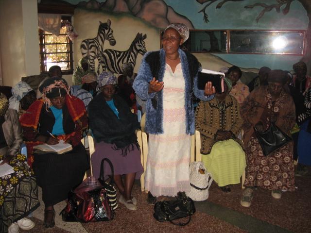 A grandmother in Kenya tells her story to a room of grandmothers.