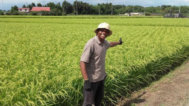 Mambud Samai pointing at farm field