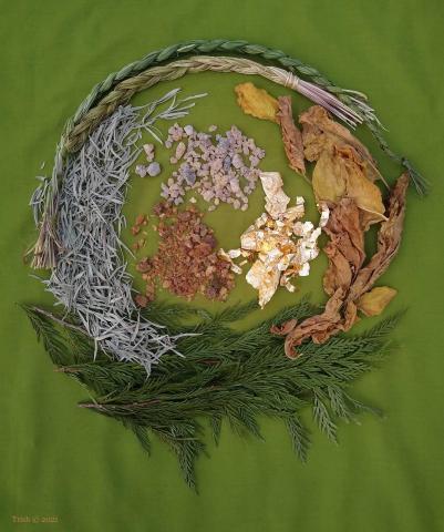 A beautiful photo of sacred medicines from both the Near East and Indigenous traditions laid out in a circle on a green cloth background..